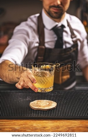 Bartender serving a ginger cocktail on the bar counter Royalty-Free Stock Photo #2249692811
