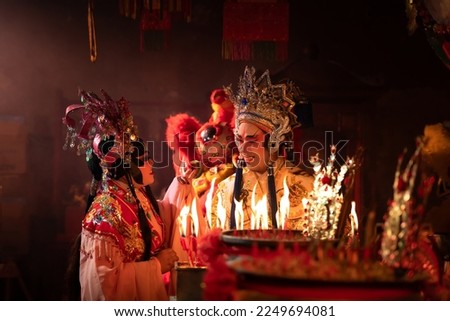 Male and female Chinese opera actors Light a candle to pray homage to the gods to enhance the prosperity for yourself on the occasion of the Chinese New Year festival.