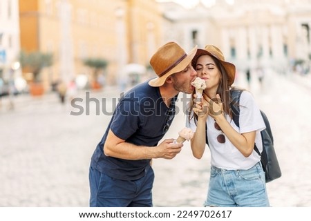 Happy couple eating ice cream in Rome, Italy. Beautiful bright ice cream with different flavors in the hands of a couple. A picture of a happy couple showing ice-cream cones
