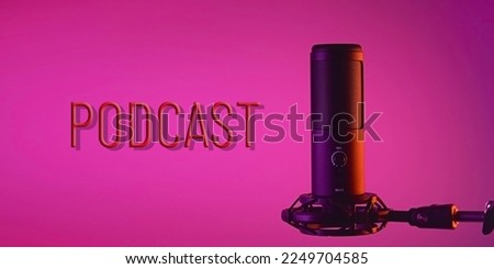 A studio condenser microphone with PODCAST written on a colored background. The concept of vocals, streaming, podcast.