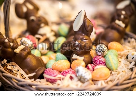 Brown basket with brown easter bunny chocolates and multi-colored easter eggs