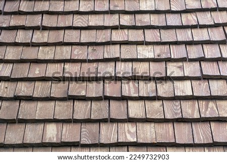 Texture and background of thick wooden shingles covering a roof. You can see the grain of the wood.