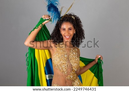 Brazilian afro woman posing in samba costume on grey background with the flag of Brazil