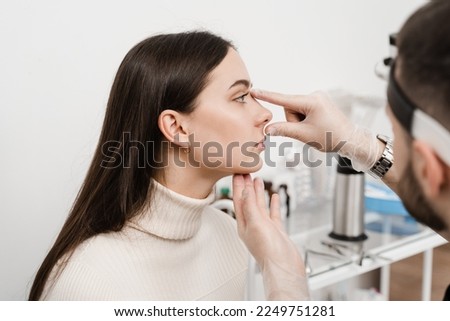 Septoplasty is surgery to correct deviated septum. Rhinoplasty is reshaping nose surgery for change appearance of the nose and improve breathing. Surgeon is touching and examining girl nose Royalty-Free Stock Photo #2249751281
