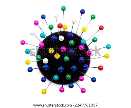 black pincushion full with with colorful pins Royalty-Free Stock Photo #2249761337
