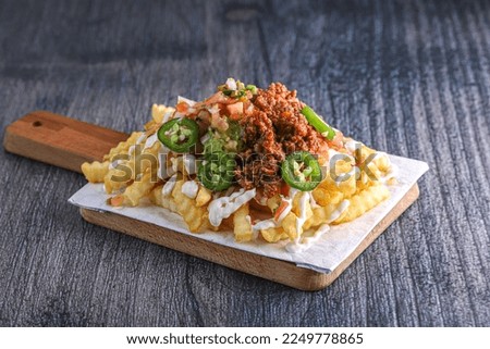Loaded crinkle cut french fries with jalapenos and bacon and cheese Royalty-Free Stock Photo #2249778865