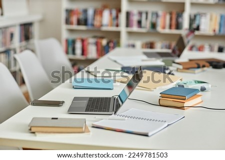 Side view background image of work table in college library with laptops and notes, copy space