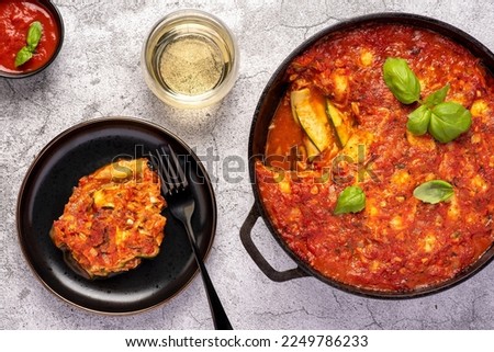 Food photography of stewed zucchini, courgette, tomato, sauce, basil, cheese, mozzarella, vegetables, casserole, ratatouille, wine