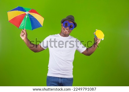 handsome black man holding a frevo umbrella, traditional in brazil carnival
