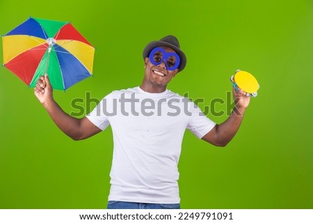 handsome black man holding a frevo umbrella, traditional in brazil carnival
