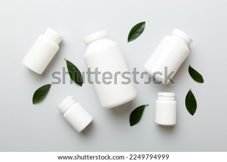 supplement pills with medicine bottle health care and medical top view. Vitamin tablets. Top view mockup bottle for pills and vitamins with green leaves, natural organic bio supplement, copy space. Royalty-Free Stock Photo #2249794999