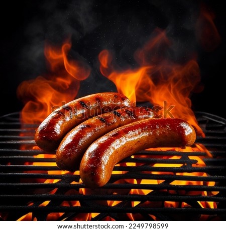 Grilled juicy sausages on a grill with fire. Shallow depth of field	 Royalty-Free Stock Photo #2249798599