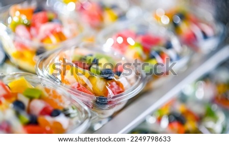 Plastic boxes with pre-packaged fruit salads, put up for sale in a commercial refrigerator Royalty-Free Stock Photo #2249798633