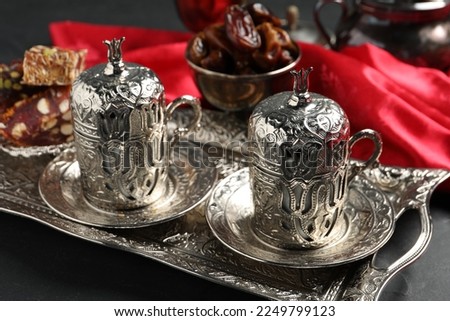 Tea, Turkish delight and date fruits served in vintage tea set on black table