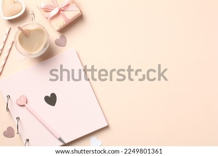 Valentine's Day flat lay composition of romantic accessories. Includes hearts, coffee cup, candles, and photo album. Great for cards, social media, and website banners