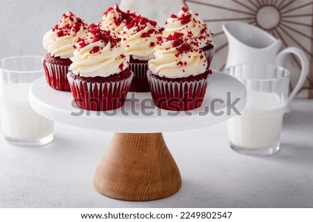 Red velvet cupcakes on a cake stand with cream cheese frosting