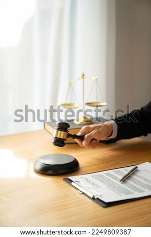 The successful female lawyer or legal advisor holding a judge's hammer in the formal office with a document signing contract. Power of attorney. Business lawyer concept.
