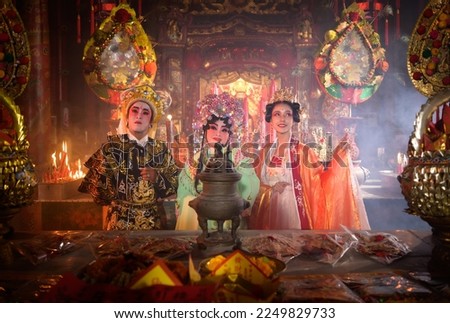 Male and female Chinese opera actors Light a candle to pray homage to the gods to enhance the prosperity for yourself on the occasion of the Chinese New Year festival.
