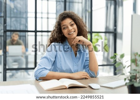 Smiling businesswoman looking at camera, make conference or business call, recording video blog, talking with client. Collegue is on the background