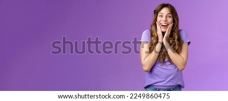 Happy lively lucky enthusiastic girl curly hairstyle open mouth admiration fascinated smiling broadly touch cheek impressed surprised awesome incredible positive news stand purple background. Royalty-Free Stock Photo #2249860475