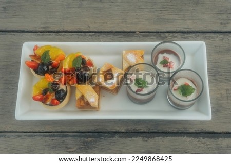 Fruit Tartlets, Apple Pie, Chocolate Pudding cuisine with grey wooden background