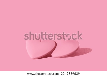 two pink hearts on pink background. Minimal monochrome for St Valentines day or 14 February. Mothers Day or wedding invitation Royalty-Free Stock Photo #2249869639