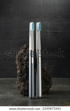 Modern sonic electric toothbrushes. Made from gray metal. Professional oral care and healthy teeth. Minimalistic design. Grey background.