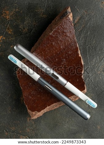 Modern sonic electric toothbrushes. Made from gray metal. Professional oral care and healthy teeth. Minimalistic design. Gray marble background.