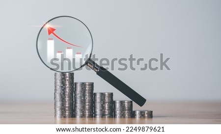 financial growth and investment ideas With new ideas, income generation and planning management for safe and achievable retirement goals,A magnifying glass is placed on a stack of silver coins. Royalty-Free Stock Photo #2249879621