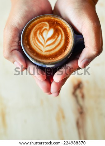 man holding hot cup of coffee latte art, coffee lover concept.