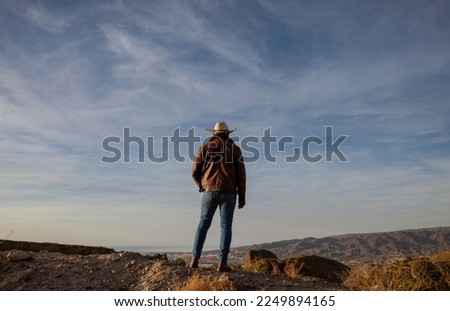 Adult man in cowboy hat standing on top of hill. Almeria, Spain