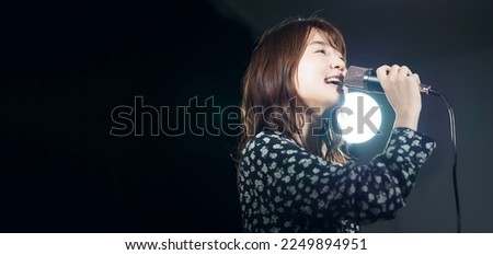 A woman singing in the spotlight. Live. concert. Karaoke. Royalty-Free Stock Photo #2249894951