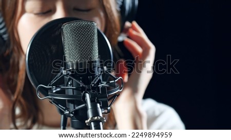 Female singer recording in studio. Royalty-Free Stock Photo #2249894959