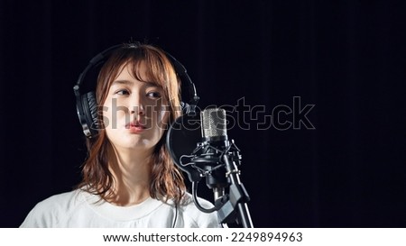 Female singer recording in studio. Royalty-Free Stock Photo #2249894963