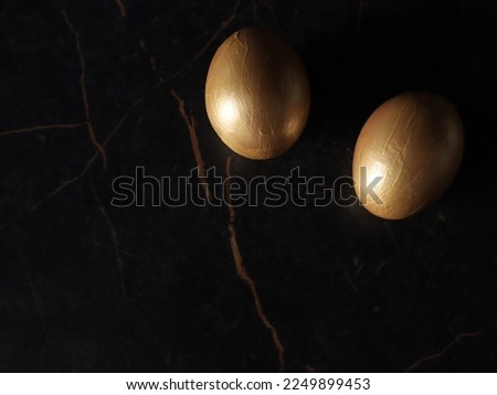 two gold Easter eggs on the dark background with a copy space. 