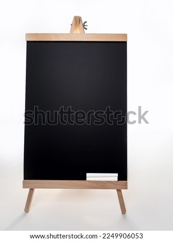 Black board with of two pieces of chalks on wooden easel isolated on white background.
