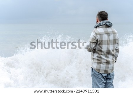 Man standing in front of a large wave