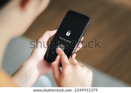 Woman using Smart phone with application for scanning fingerprint. Cyber security of personal device.  Royalty-Free Stock Photo #2249915379
