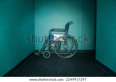 Silhouette of empty wheelchair parked in the hospital corridor