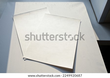 Hand holding a blank a4 size paper isolated on grey background