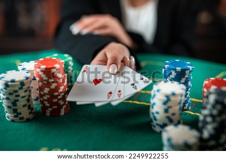 female hand takes poker chips from a pile at a round poker table. risky bets in poker. a woman plays a man's game. woman's hands Royalty-Free Stock Photo #2249922255