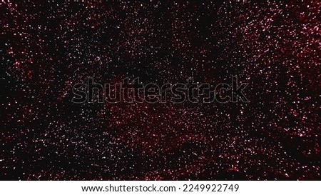 Sparkling background. Grain texture. Bokeh glow. Defocused shimmering red pink black color glitter sparks on dark abstract free space.