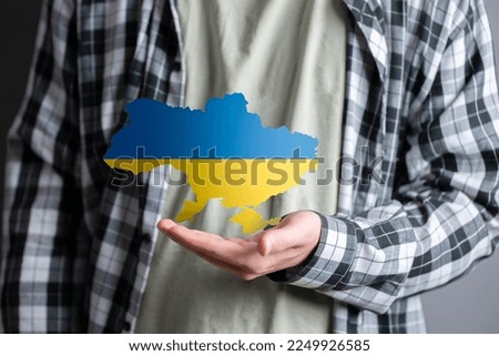 person holding ukranian map in blue and yellow colors