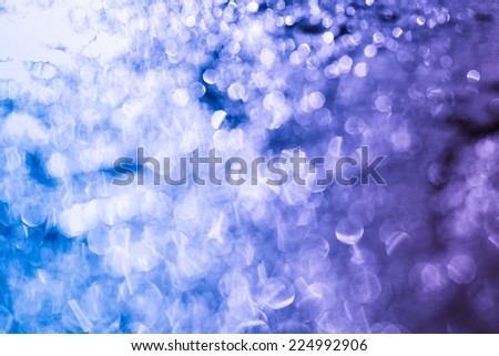 Photo of blue background with bokeh circles. Selective focus. Color toned image. Low depth of field. Copy space.