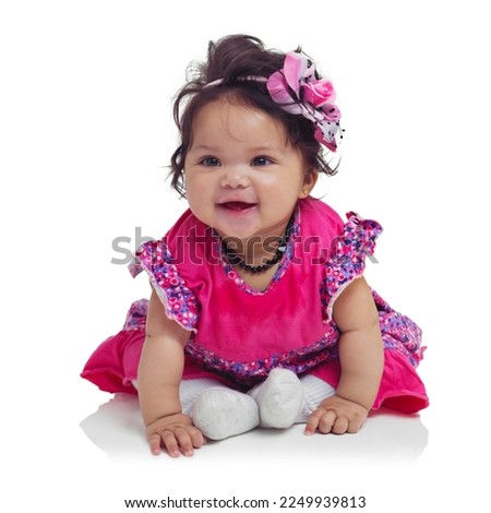Innocent, cute and happy baby girl in a studio with a floral, beautiful and flower outfit and headband. Happiness, smile and infant child sitting and playing while isolated by a white background.