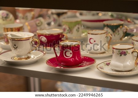 Traditional Turkish coffee mugs with star and crescent, red and white retro mug in a gift shop in Istanbul, decorative porcelain cups, cultural Turkish tea set