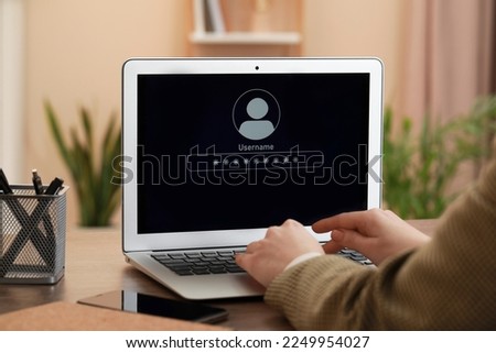 Woman unlocking laptop with blocked screen indoors, closeup Royalty-Free Stock Photo #2249954027