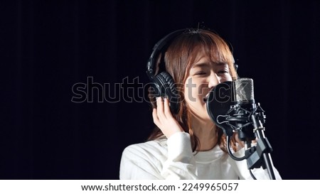 Female singer recording in studio. Royalty-Free Stock Photo #2249965057