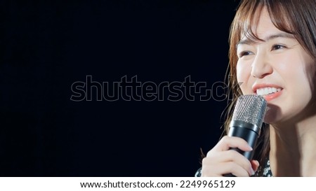 A woman singing in the spotlight. Live. concert. Karaoke. Royalty-Free Stock Photo #2249965129