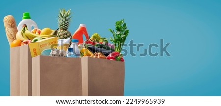 Paper grocery bags full of groceries: commerce and retail concept Royalty-Free Stock Photo #2249965939